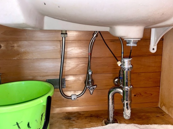 洗面台排水トラップ交換工事　工事前　洗面台下収納部既設排水トラップ