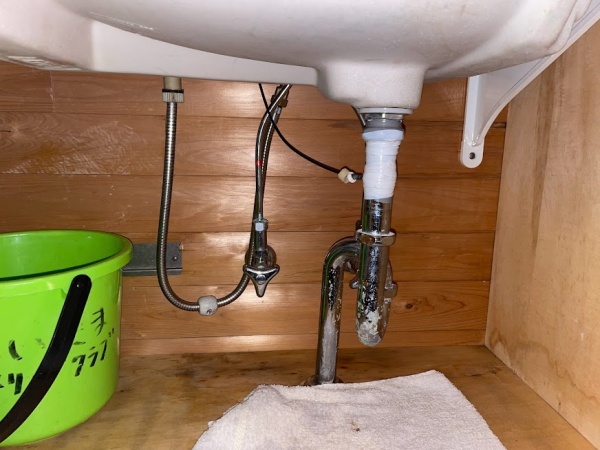 洗面台排水トラップ交換工事　工事前　洗面台下収納部既設排水トラップ（応急処置後）