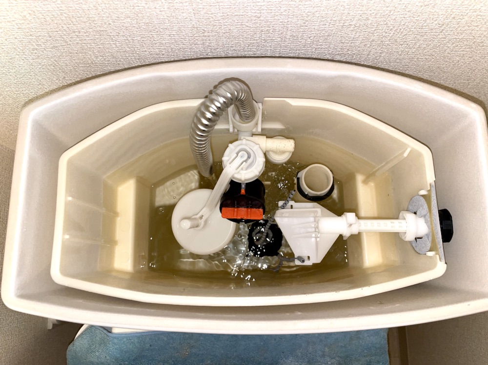 トイレ水漏れ修理工事　工事中　トイレタンク内部新規部品取り付け工事後動作確認中