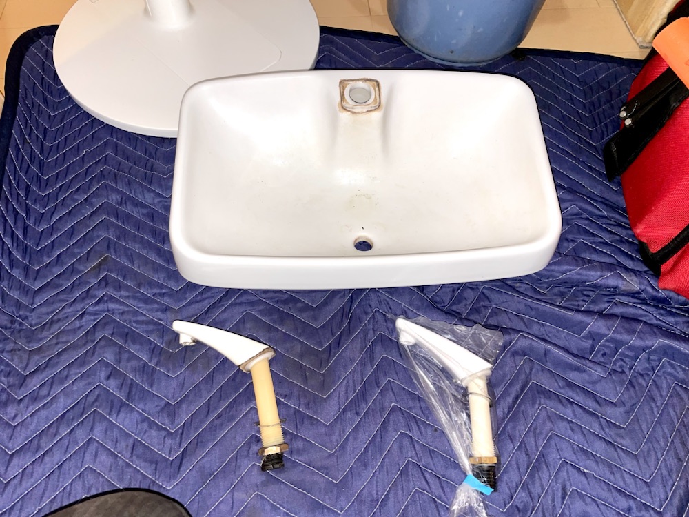 トイレ水漏れ修理工事　工事中　トイレタンク蓋既設手洗い吐水口取り外し工事後　左側　既設　右側　新規