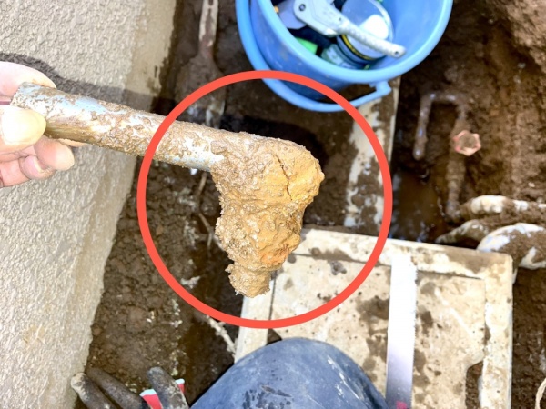 水道修理（給水管漏水）工事　工事中　建物外部　赤丸部分が漏水原因箇所